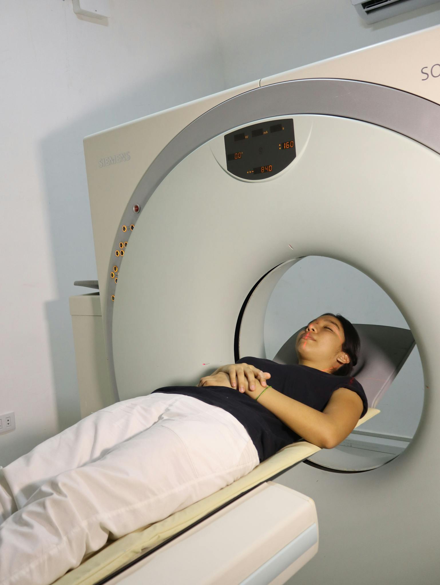 A woman lying inside an MRI machine during a medical procedure in a hospital setting.
