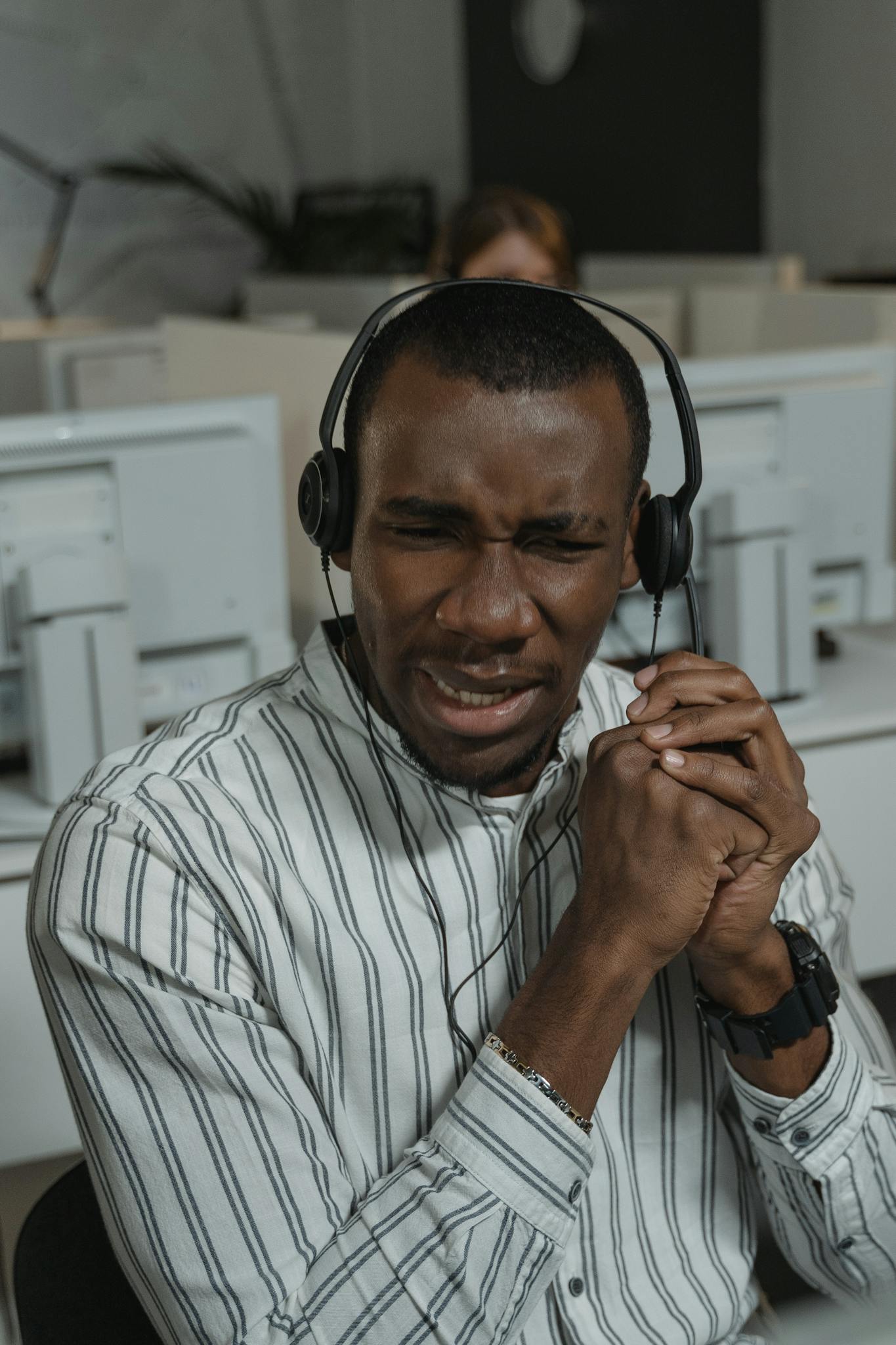 Focused call center agent providing technical support in a busy office.